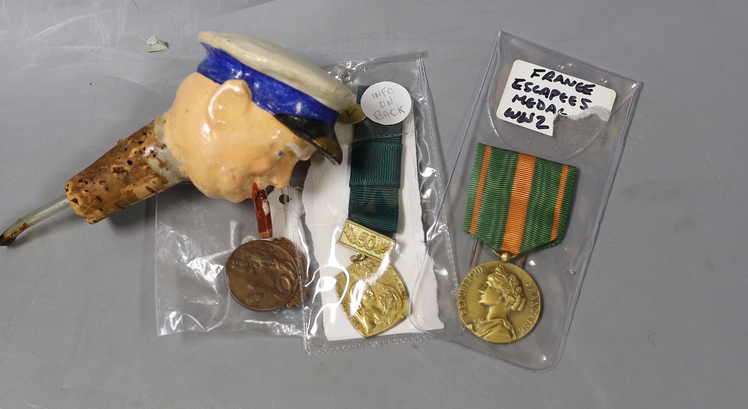 WWII interest: a Churchill composition drinks dispenser, France Escapees medal, a British Hitler hate club badge and a North Vietnam women's Defence of the Fatherland medal